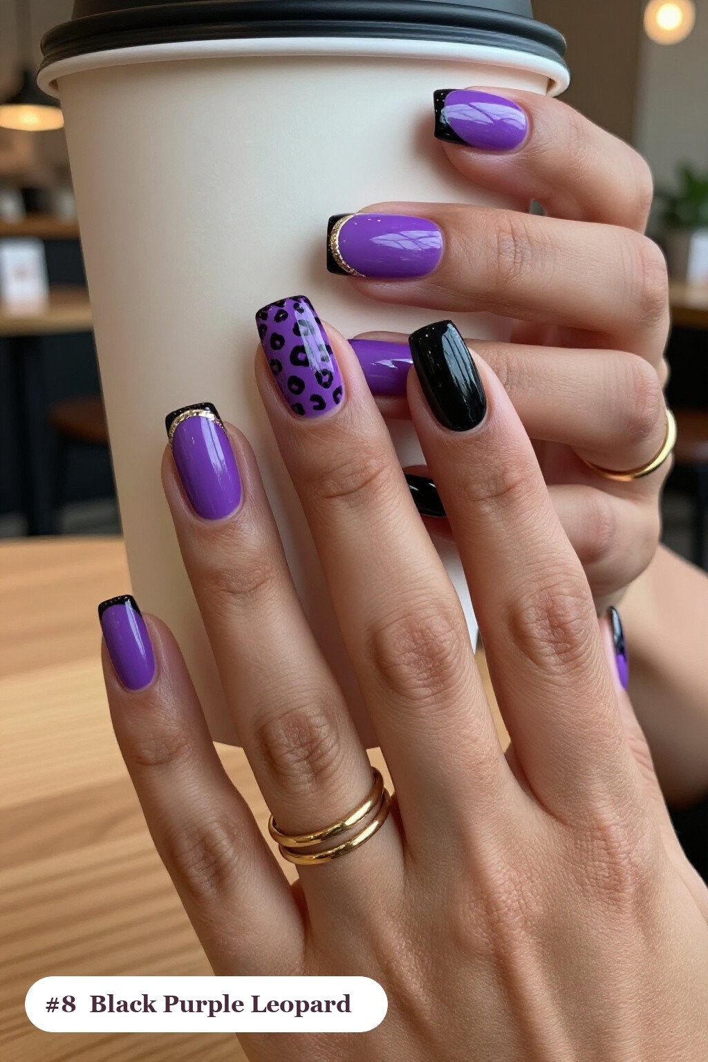 Medium square black purple nails with a leopard print pattern on two accent nails and solid colour on the rest, with champagne details, perfect for halloween - black and purple halloween nail designs