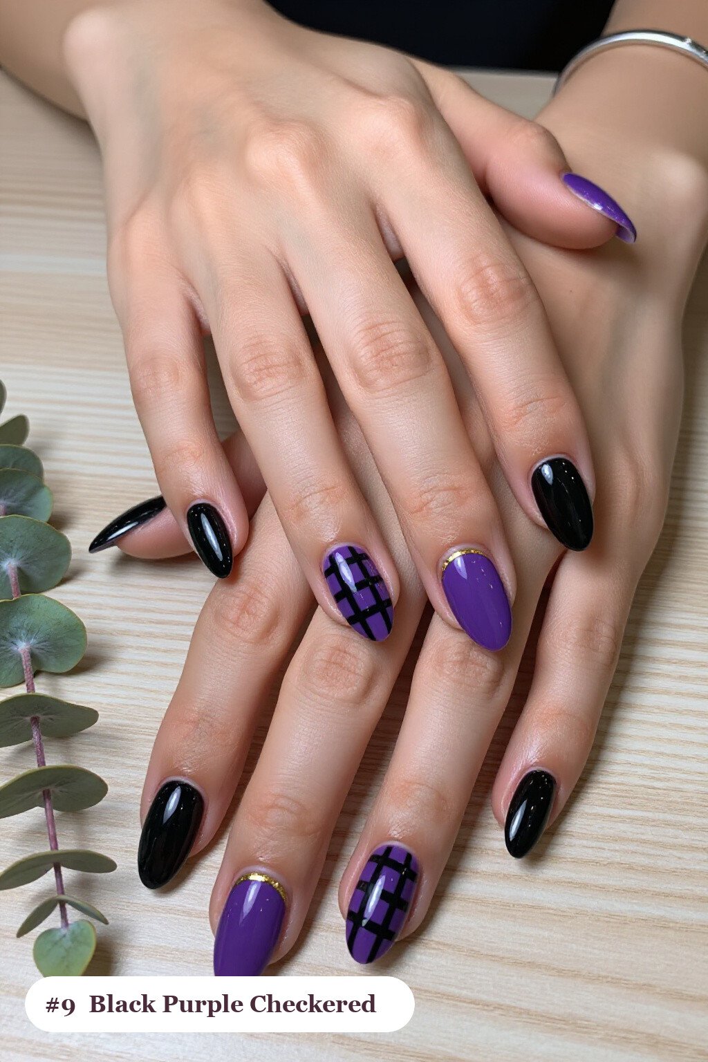 Medium almond black purple nails with a bold checkerboard pattern on two accent nails and solid colour on the rest, with gold details, perfect for halloween - black and purple halloween nail designs