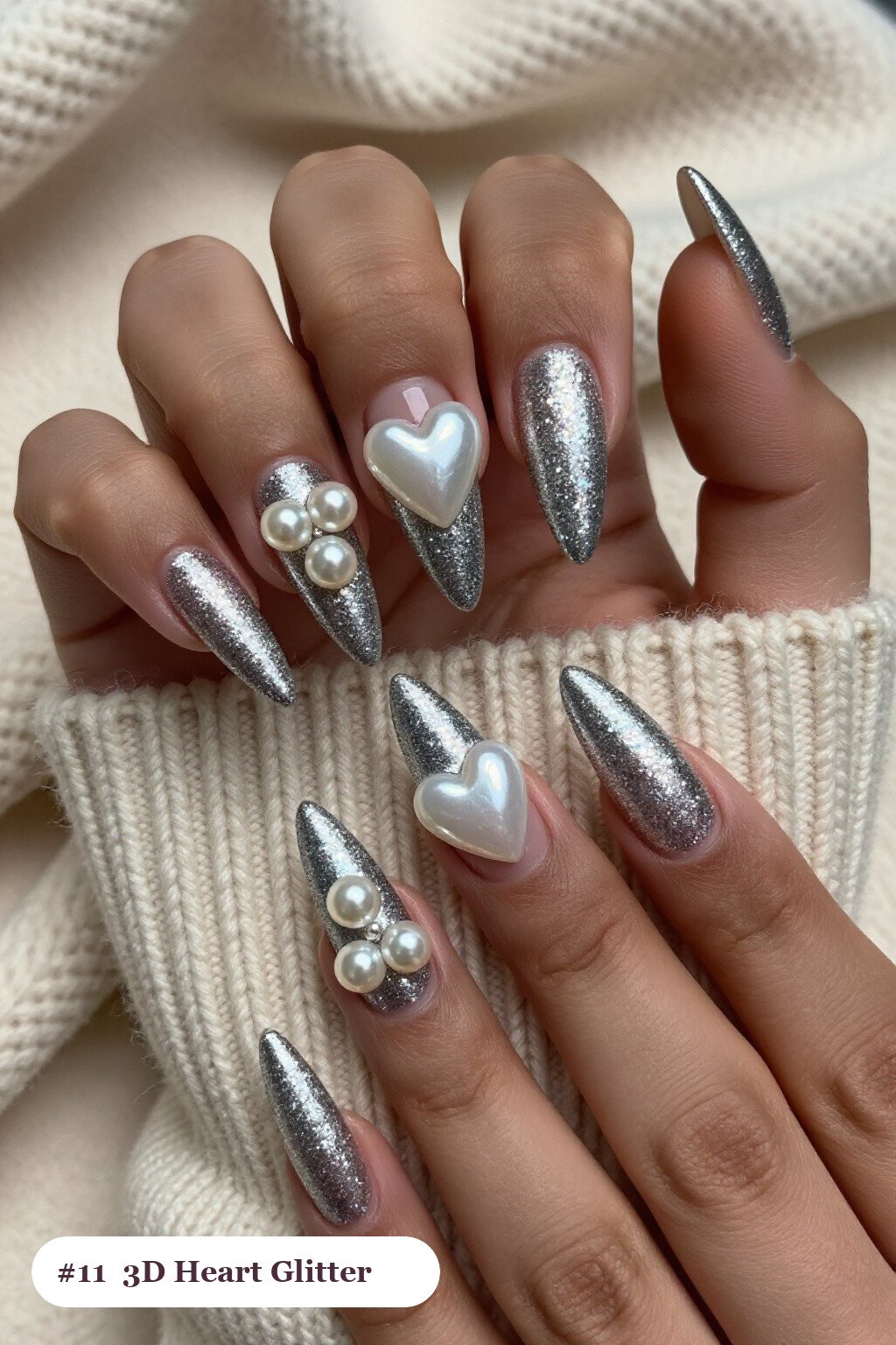 Long stiletto silver glitter nails with sparkling glitter clearly visible on every nail, styled with chunky 3D gel hearts and pearls on three nails, perfect for christmas - christmas glitter nails