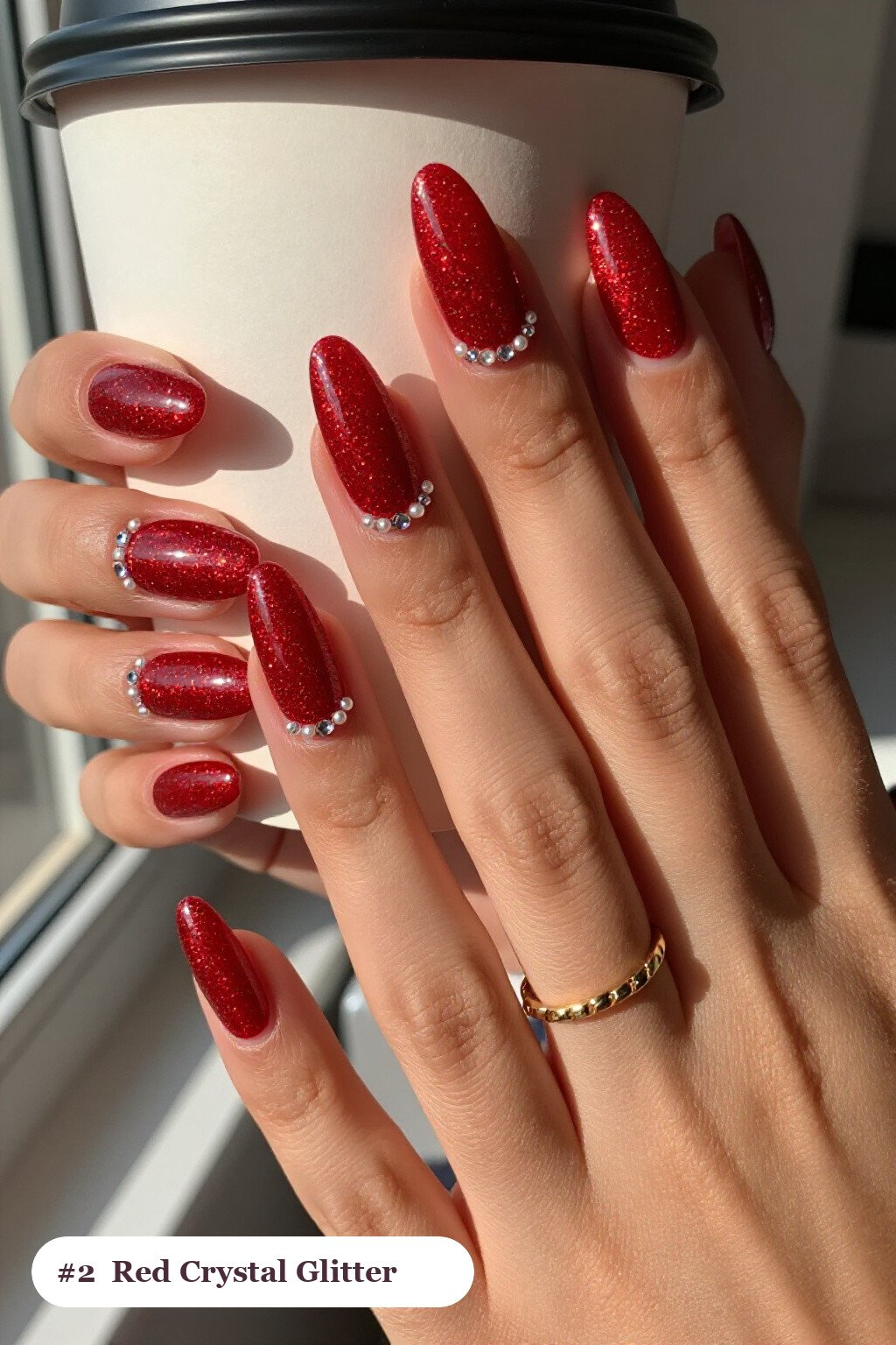 Medium almond glitter red nails with sparkling glitter clearly visible on every nail, styled with rows of sparkling crystal rhinestones along the cuticle of every nail, with pearl details, perfect for christmas - christmas glitter nails red