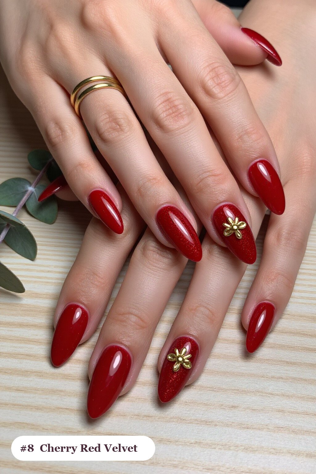 Long almond cherry red nails in a velvet shimmer finish with one glossy accent nail with a gold charm, perfect for christmas - christmas nail designs holiday