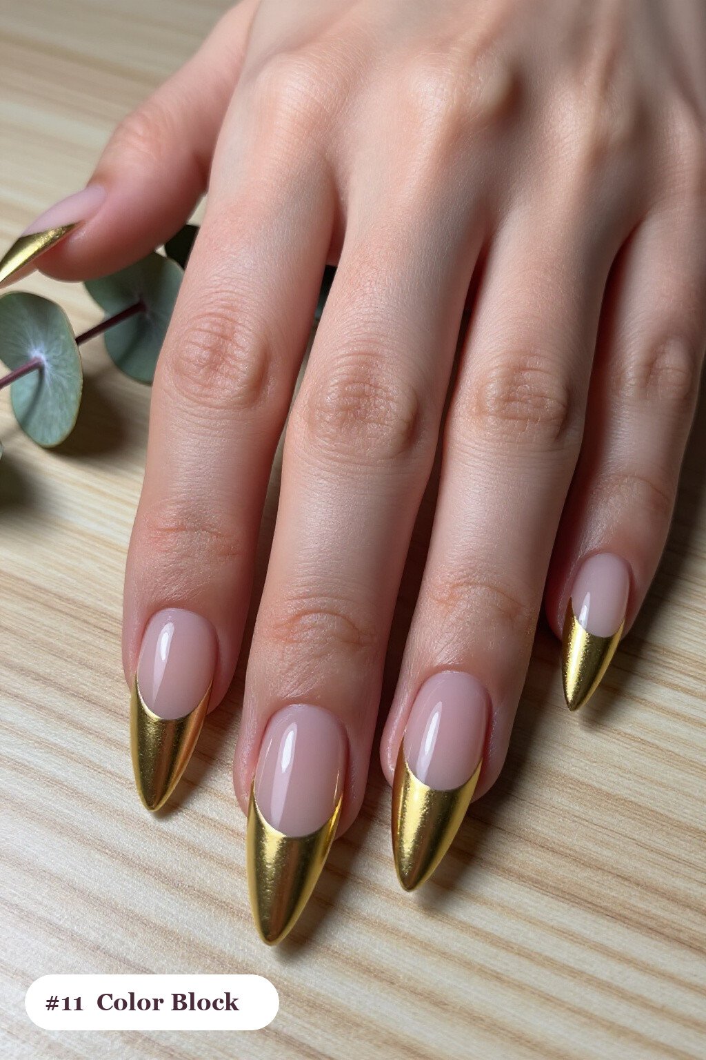 Long stiletto gold 2026 trends nails in a colour-block design split diagonally with a thin gold line, perfect for christmas - christmas nails 2026 trends