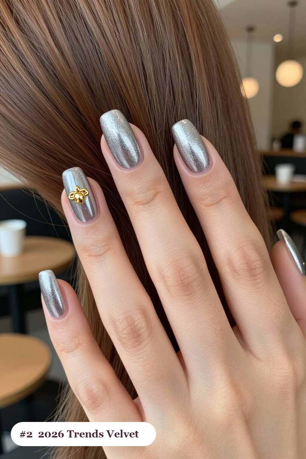 Medium square silver 2026 trends nails in a velvet shimmer finish with one glossy accent nail with a gold charm, perfect for christmas - christmas nails 2026 trends