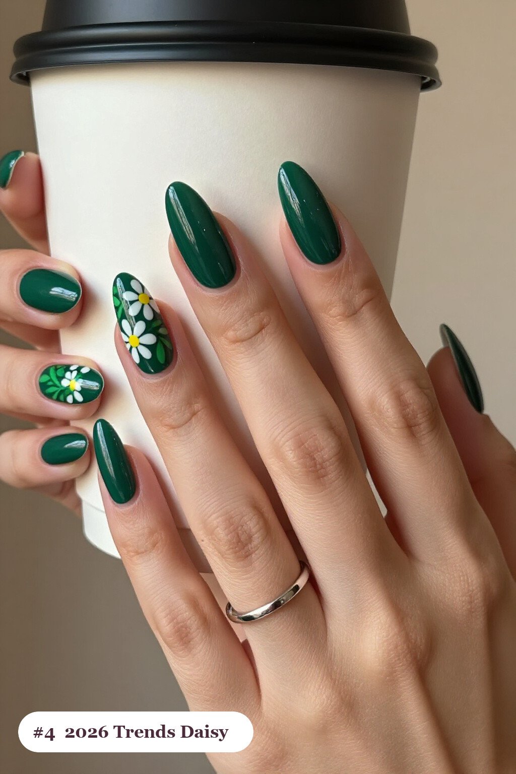 Long almond emerald green 2026 trends nails with hand-painted daisies and green leaves across every nail, perfect for christmas - christmas nails 2026 trends