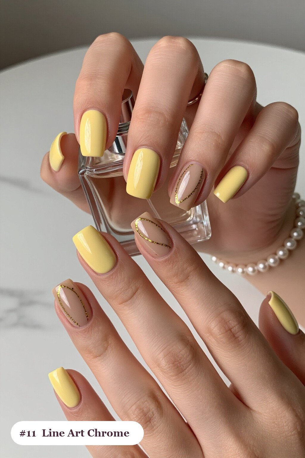 Short square butter yellow coffee chrome nails with a liquid chrome mirror finish clearly visible on every nail, styled with fine gold line art and tiny dots drawn across every nail - coffee chrome nails