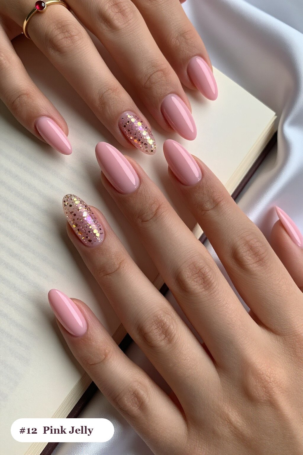 Medium almond pink nails in a see-through jelly finish with encapsulated glitter, with gold details, perfect for halloween - cute halloween nails pink
