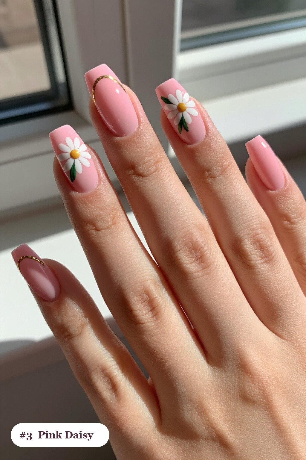 Medium square pink nails with hand-painted daisies and green leaves across every nail, with gold details, perfect for halloween - cute halloween nails pink