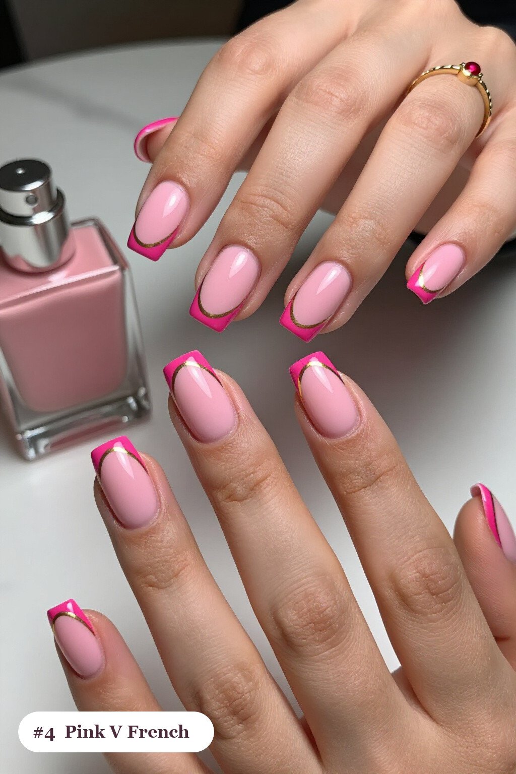 Short square pink nails with deep V-shaped french tips in a bold contrasting colour, with gold details, perfect for halloween - cute halloween nails pink
