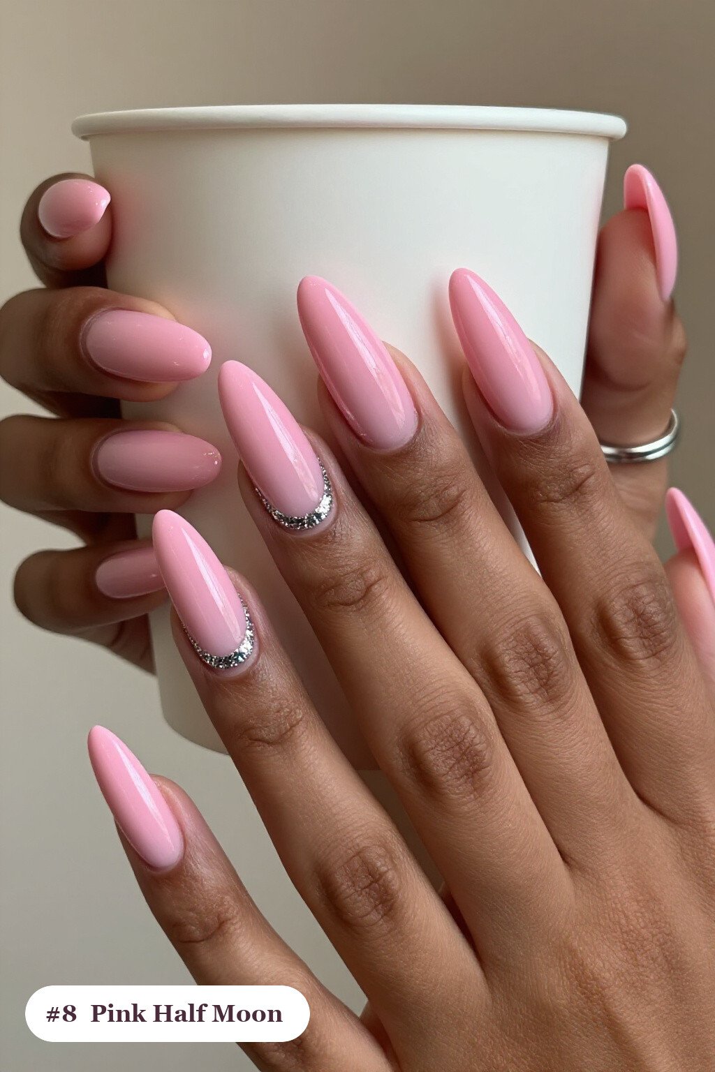 Long coffin pink nails in a half-moon design with a glitter crescent at the cuticle, with silver chrome details, perfect for halloween - cute halloween nails pink