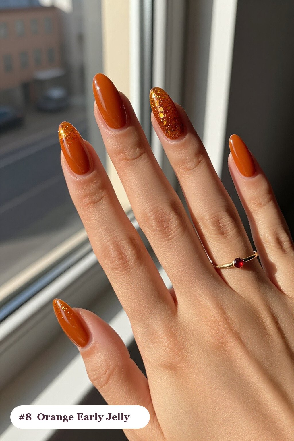 Long almond burnt orange early nails in a see-through jelly finish with encapsulated glitter, perfect for fall - early fall nail designs
