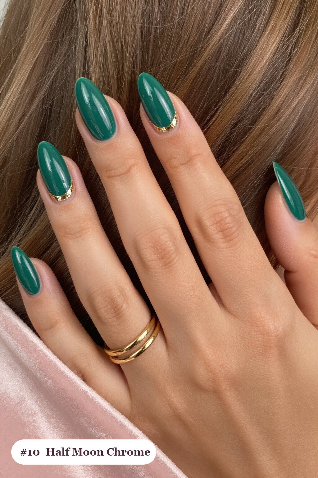 Medium almond emerald chrome nails with a liquid chrome mirror finish clearly visible on every nail, styled with a half-moon design with a glitter crescent at the cuticle, with gold details - emerald chrome almond nails