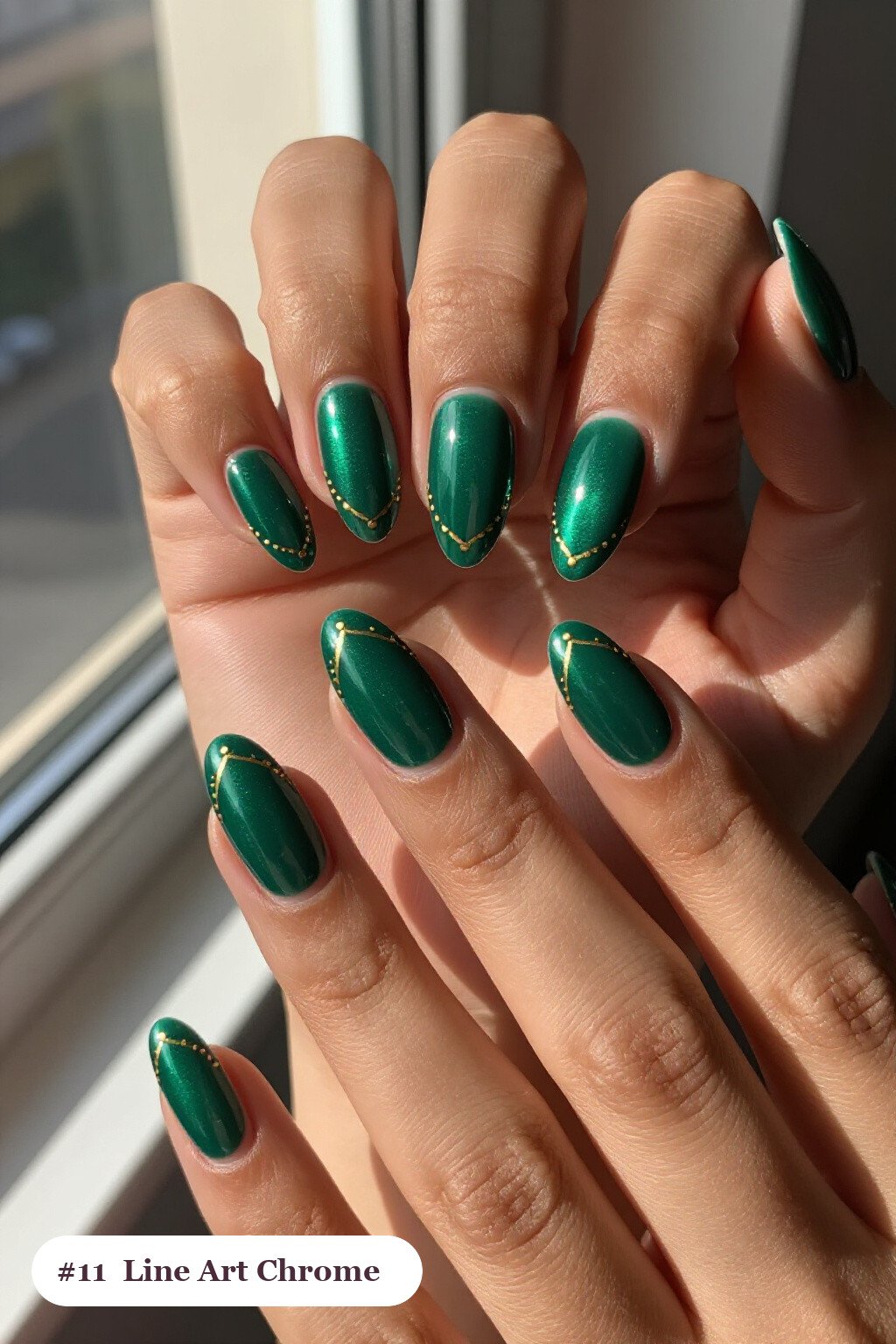 Medium almond emerald chrome nails with a liquid chrome mirror finish clearly visible on every nail, styled with fine gold line art and tiny dots drawn across every nail - emerald chrome almond nails