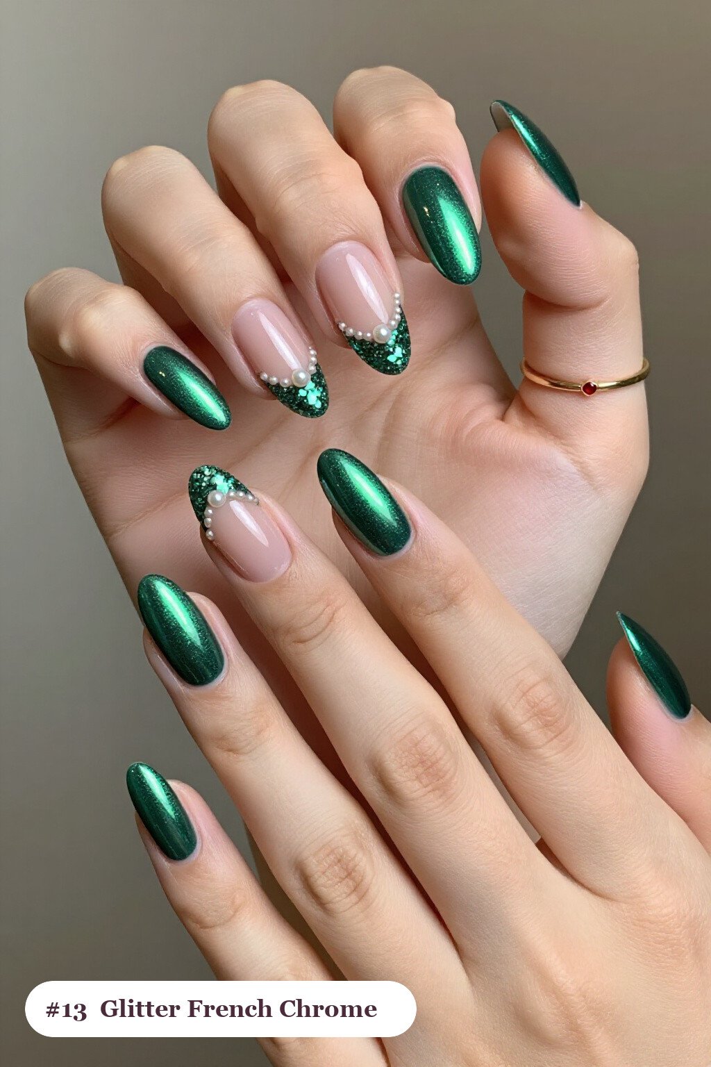 Medium almond emerald chrome nails with a liquid chrome mirror finish clearly visible on every nail, styled with glitter-packed french tips over a sheer nude base, with pearl details - emerald chrome almond nails