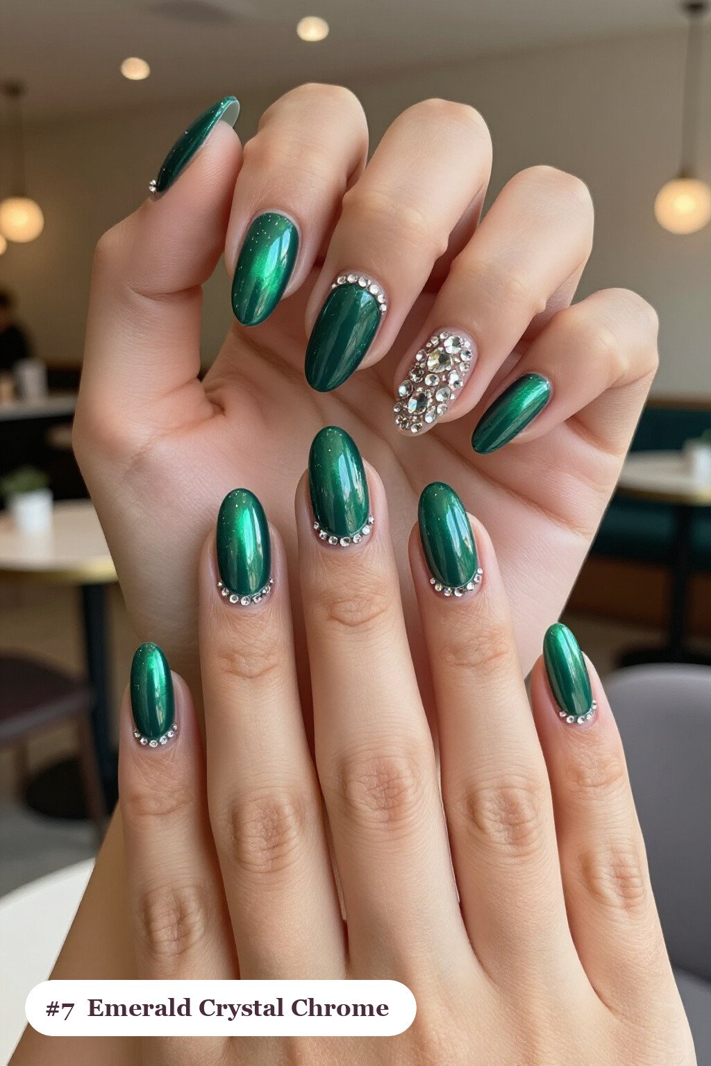 Medium almond emerald chrome nails with a liquid chrome mirror finish clearly visible on every nail, styled with rows of sparkling crystal rhinestones along the cuticle of every nail, with silver details - emerald chrome almond nails