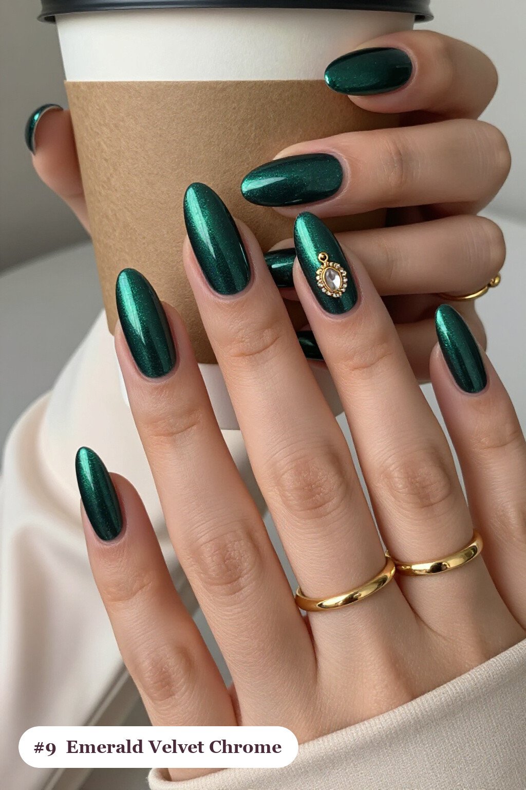 Medium almond emerald chrome nails with a liquid chrome mirror finish clearly visible on every nail, styled with a velvet shimmer finish with one glossy accent nail with a gold charm, with champagne details - emerald chrome almond nails