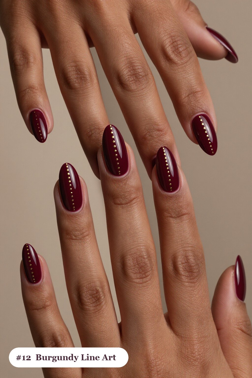Medium almond burgundy nails with fine gold line art and tiny dots drawn across every nail, perfect for fall - fall almond nails designs