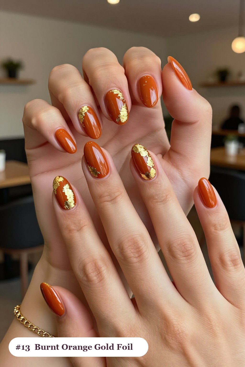 Medium almond burnt orange nails with dense gold foil flakes and gold leaf scattered across every nail, perfect for fall - fall almond nails designs