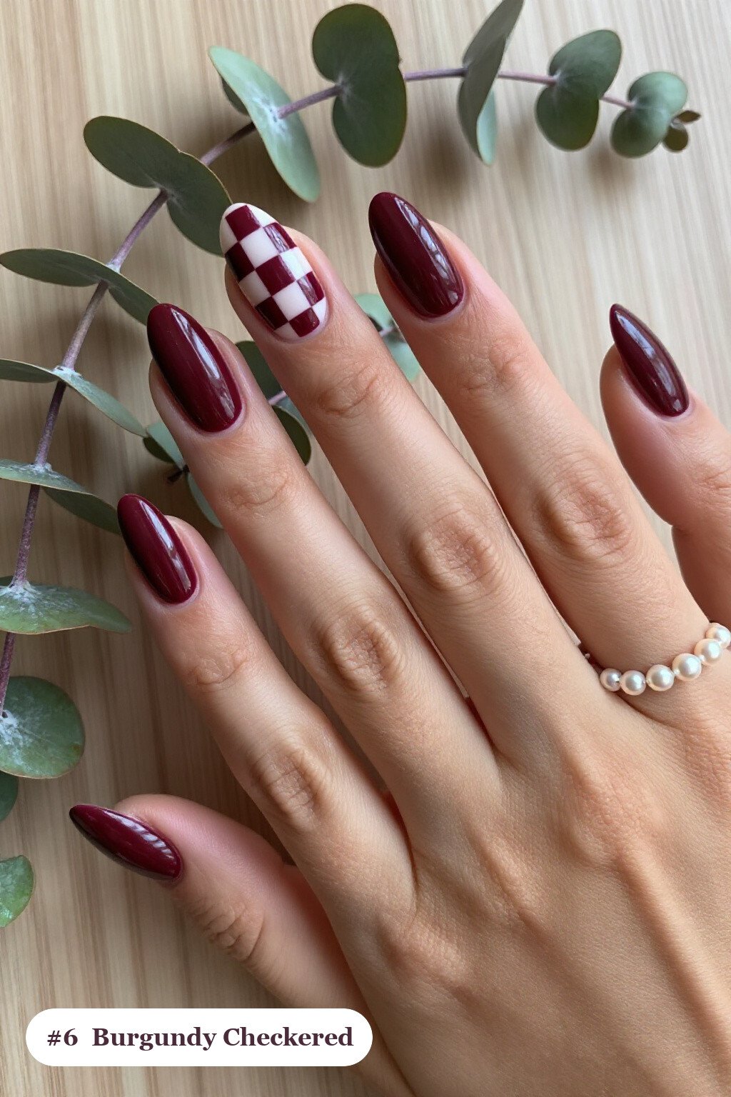 Medium almond burgundy nails with a bold checkerboard pattern on two accent nails and solid colour on the rest, perfect for fall - fall almond nails designs