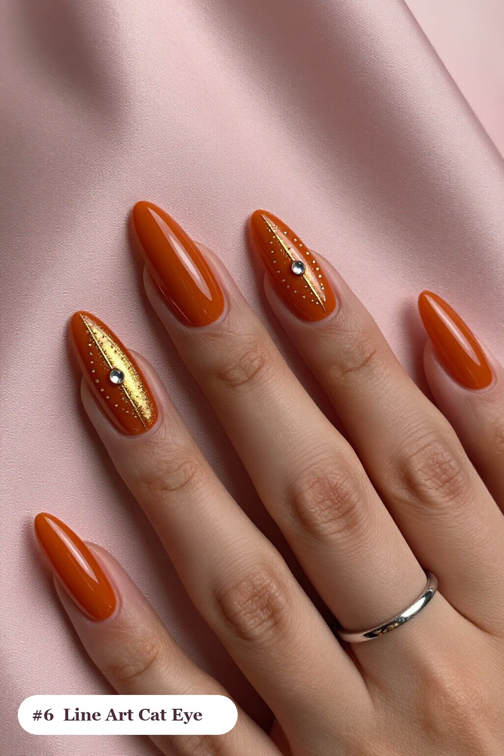 Long almond burnt orange cateye nails with a glowing magnetic cat eye shimmer band running down the centre of each nail like a gemstone clearly visible on every nail, styled with fine gold line art and tiny dots drawn across every nail, perfect for fall - fall cateye nails Long almond burnt orange cateye nails with a glowing magnetic cat eye shimmer band running down the centre of each nail like a gemstone clearly visible on every nail, styled with fine gold line art and tiny dots drawn across every nail, perfect for fall - fall cateye nails