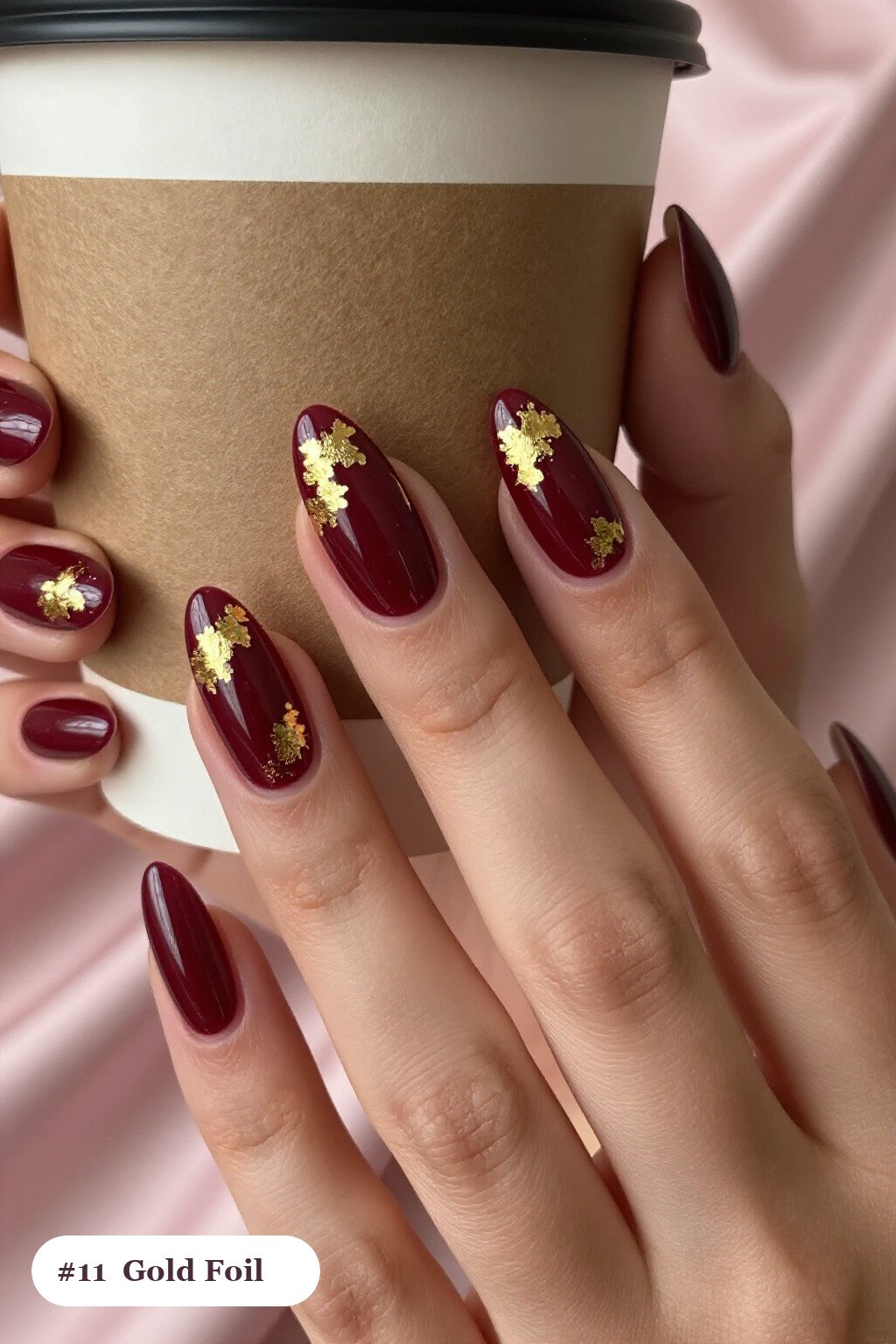 Long ballerina burgundy colors nails with dense gold foil flakes and gold leaf scattered across every nail, perfect for fall - fall nail colors