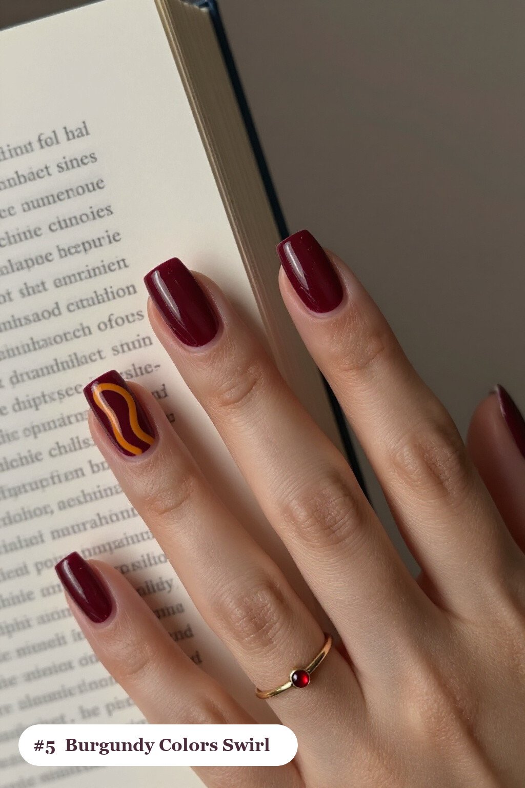 Short square burgundy colors nails with bold hand-painted swirl lines flowing across every nail in a contrasting colour, perfect for fall - fall nail colors