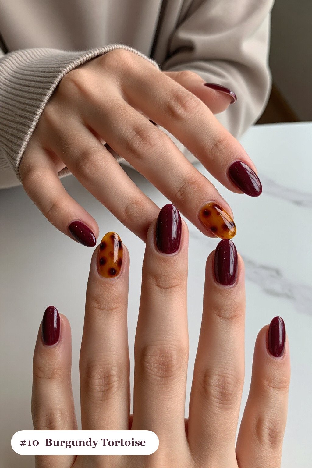 Short almond burgundy nails with glossy amber tortoiseshell on two accent nails, perfect for fall - fall nails short