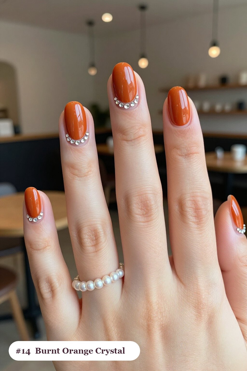 Short almond burnt orange nails with rows of sparkling crystal rhinestones along the cuticle of every nail, perfect for fall - fall nails short