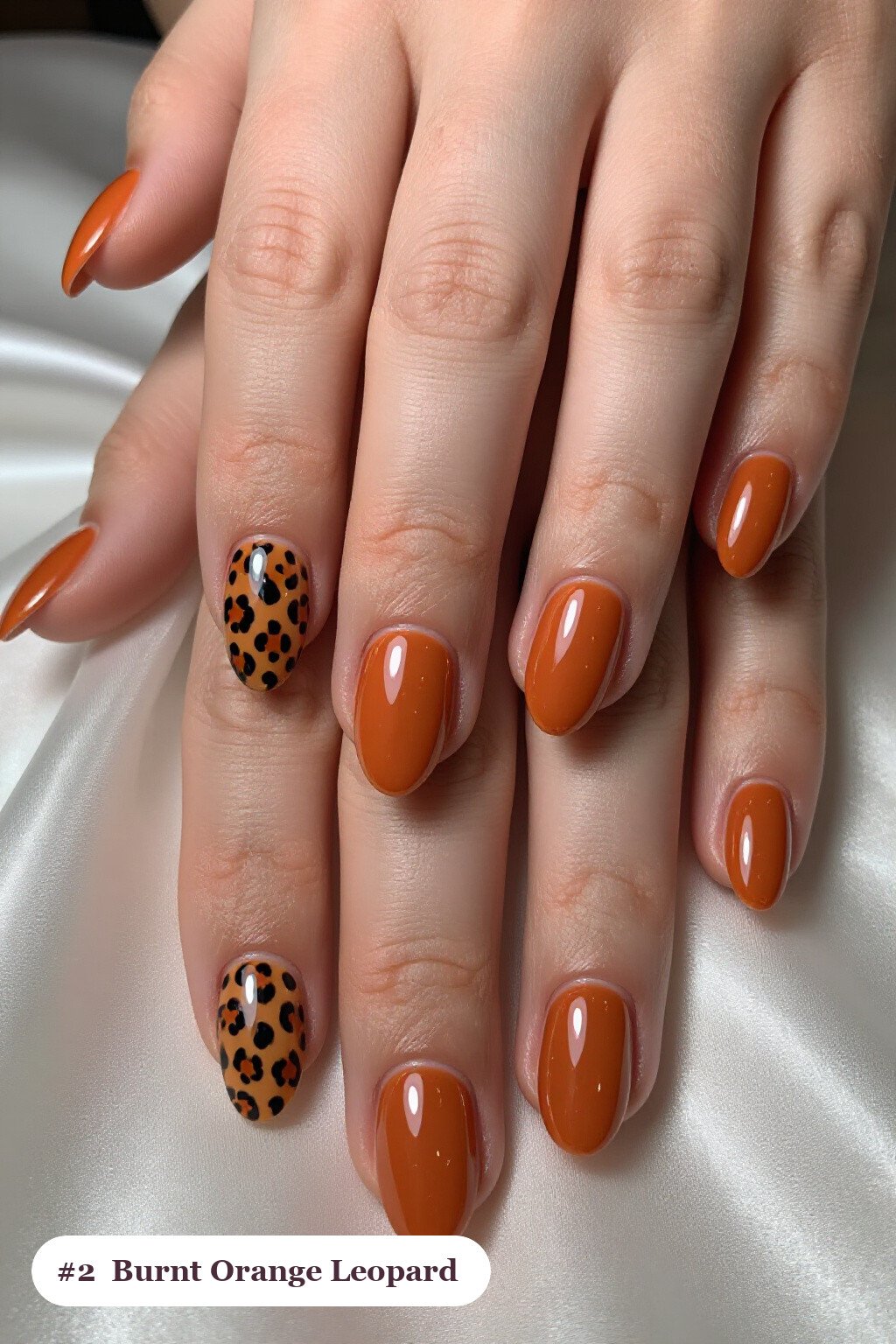 Short almond burnt orange nails with a leopard print pattern on two accent nails and solid colour on the rest, perfect for fall - fall nails short