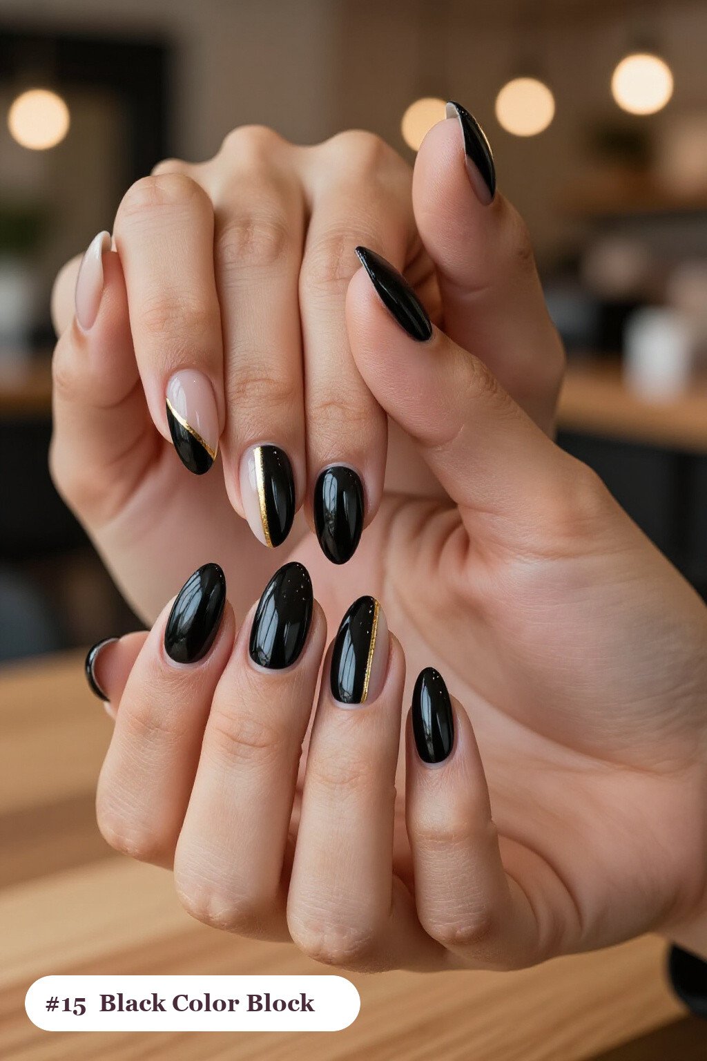 Medium almond black nails in a colour-block design split diagonally with a thin gold line, perfect for halloween - halloween almond nails