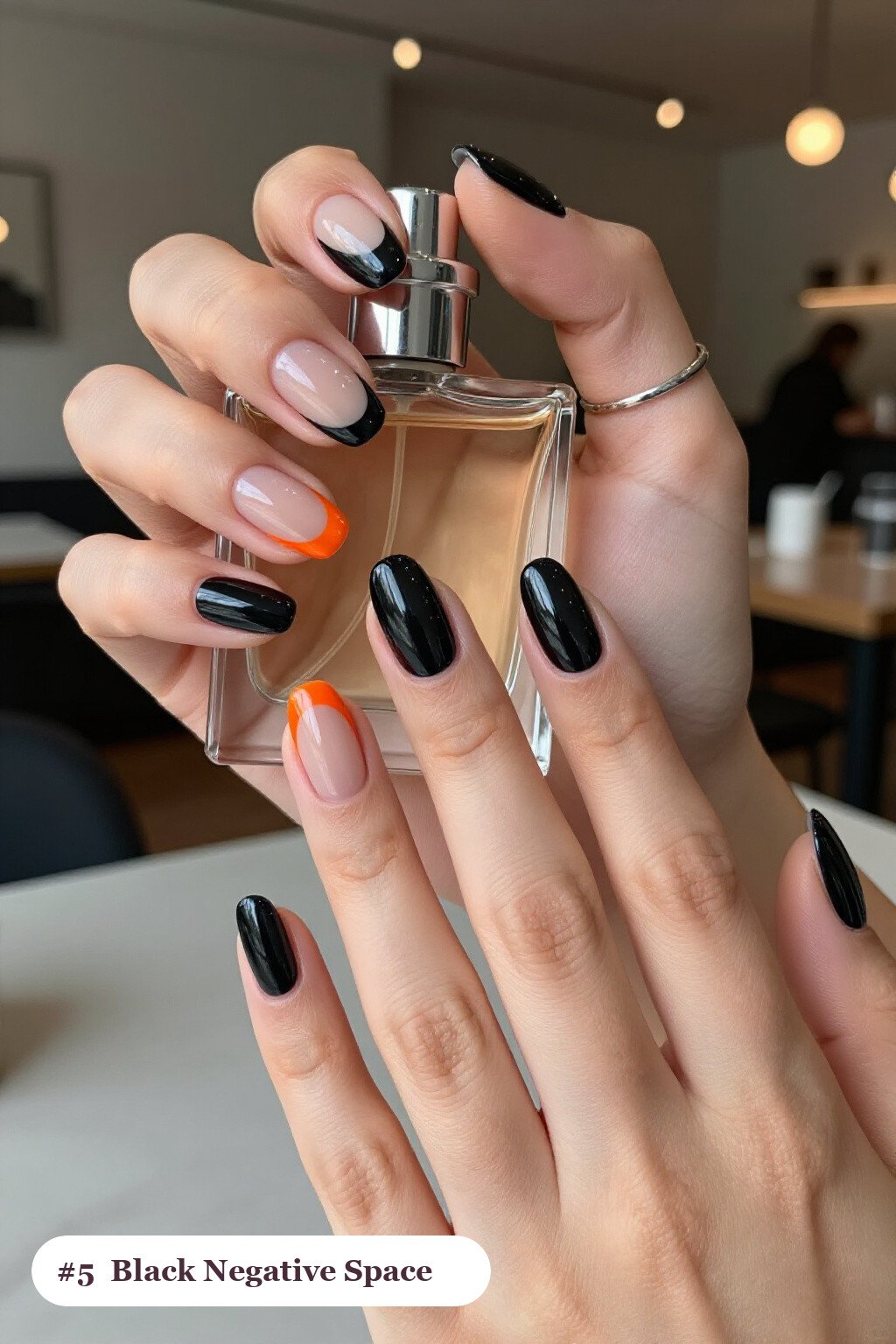 Medium oval black nails in a negative-space design with sheer nude windows and bold colour shapes, perfect for halloween - halloween nails