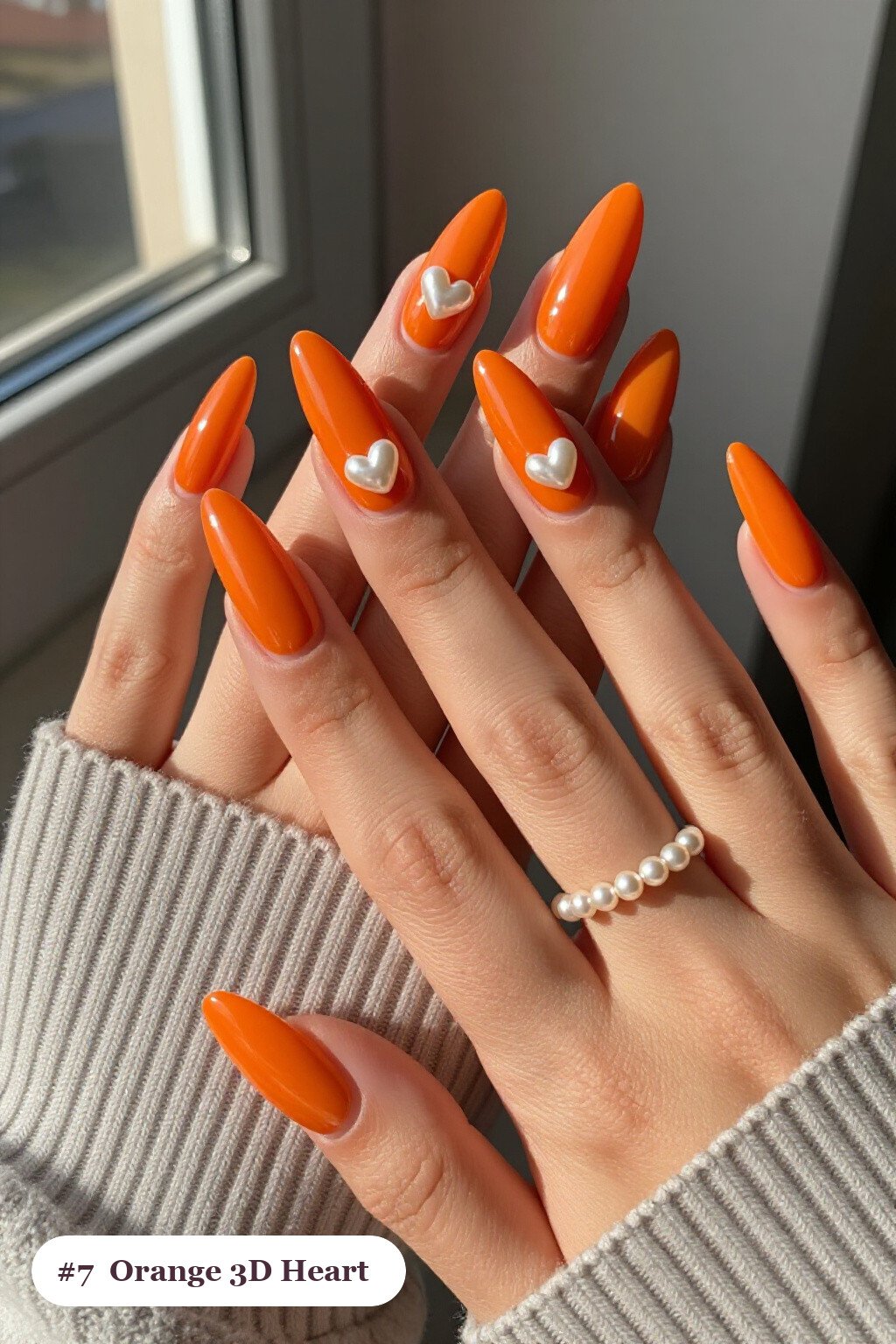 Long almond orange nails with chunky 3D gel hearts and pearls on three nails, perfect for halloween - halloween nails