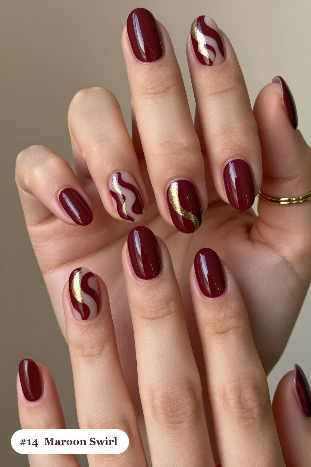 Medium oval maroon nails with bold hand-painted swirl lines flowing across every nail in a contrasting colour, with champagne details, perfect for fall - maroon fall nails Medium oval maroon nails with bold hand-painted swirl lines flowing across every nail in a contrasting colour, with champagne details, perfect for fall - maroon fall nails