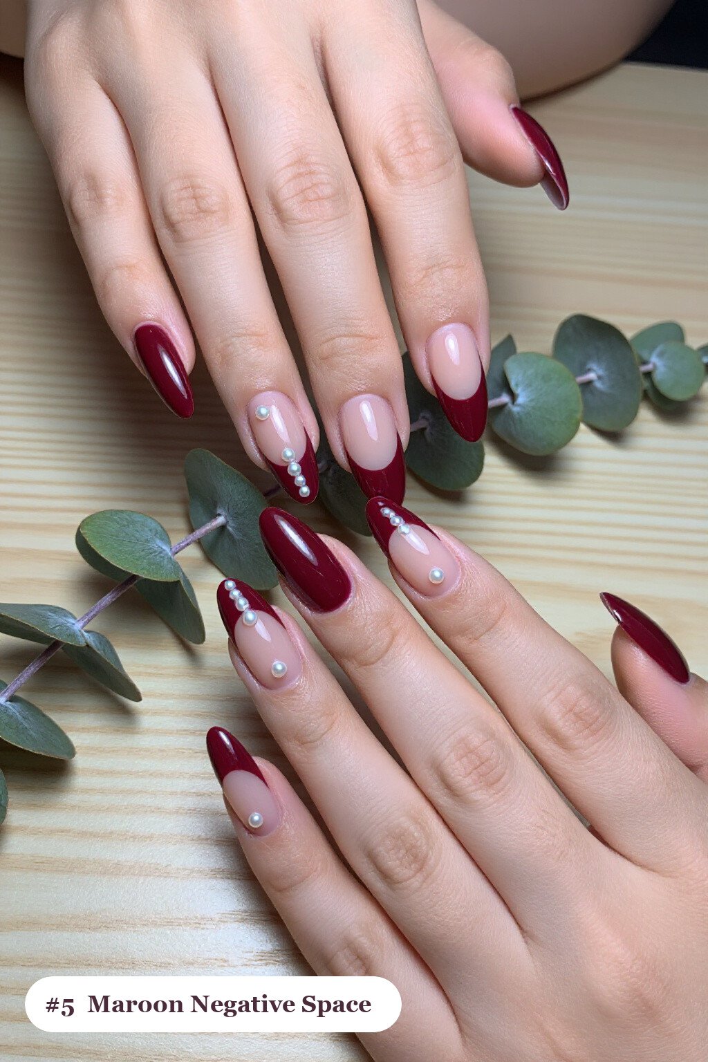 Long almond maroon nails in a negative-space design with sheer nude windows and bold colour shapes, with pearl details, perfect for fall - maroon fall nails Long almond maroon nails in a negative-space design with sheer nude windows and bold colour shapes, with pearl details, perfect for fall - maroon fall nails