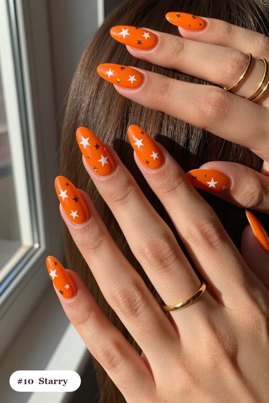 Long ballerina orange minimalist nails with white and gold stars and sparkles painted on every nail, perfect for halloween - minimalist halloween nails