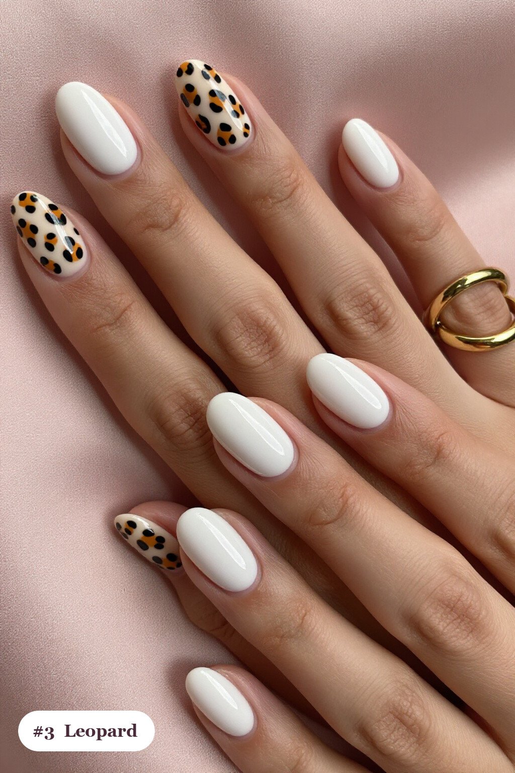 Medium oval bone white minimalist nails with a leopard print pattern on two accent nails and solid colour on the rest, perfect for halloween - minimalist halloween nails