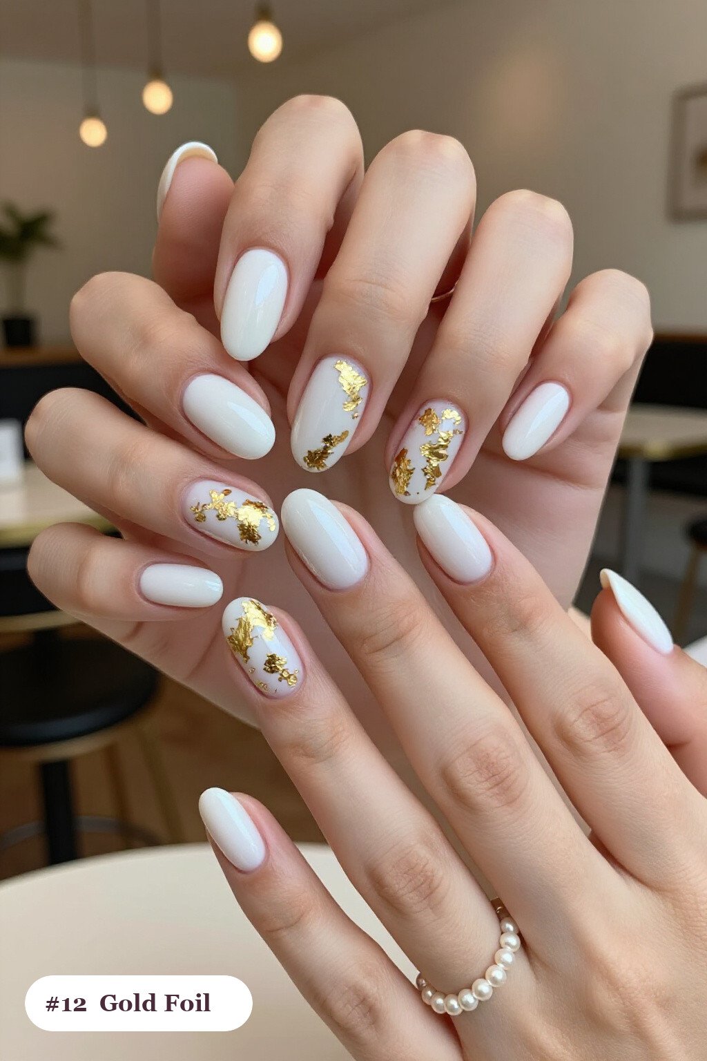 Medium oval milky white october nails with dense gold foil flakes and gold leaf scattered across every nail - october nail ideas Medium oval milky white october nails with dense gold foil flakes and gold leaf scattered across every nail - october nail ideas