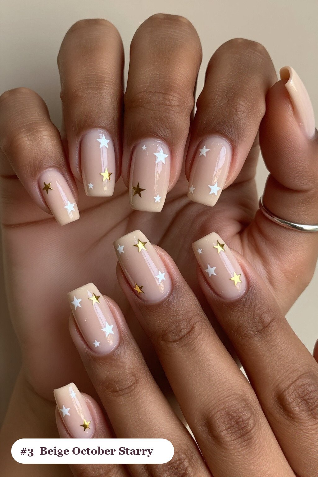 Medium square nude beige october nails with white and gold stars and sparkles painted on every nail - october nail ideas Medium square nude beige october nails with white and gold stars and sparkles painted on every nail - october nail ideas