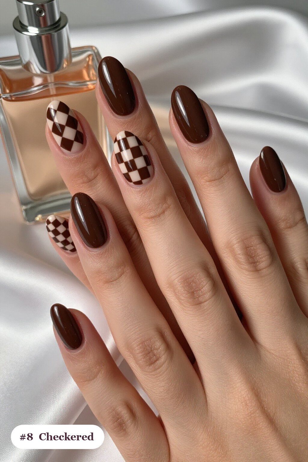 Medium coffin chocolate brown october nails with a bold checkerboard pattern on two accent nails and solid colour on the rest - october nail ideas Medium coffin chocolate brown october nails with a bold checkerboard pattern on two accent nails and solid colour on the rest - october nail ideas