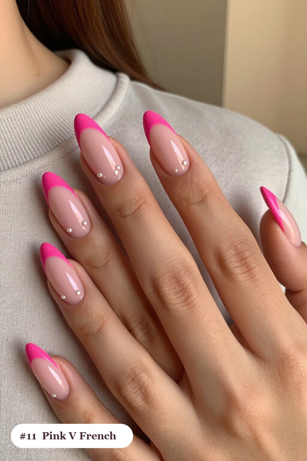 Medium almond pink nails with deep V-shaped french tips in a bold contrasting colour, with pearl details - pink nails almond