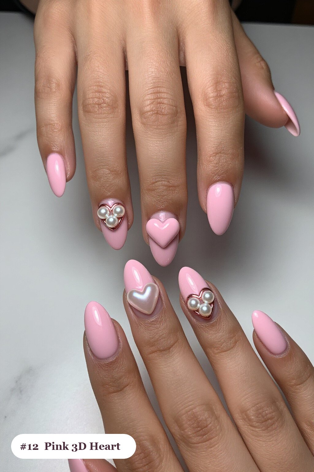 Medium almond pink nails with chunky 3D gel hearts and pearls on three nails, with rose gold details - pink nails almond