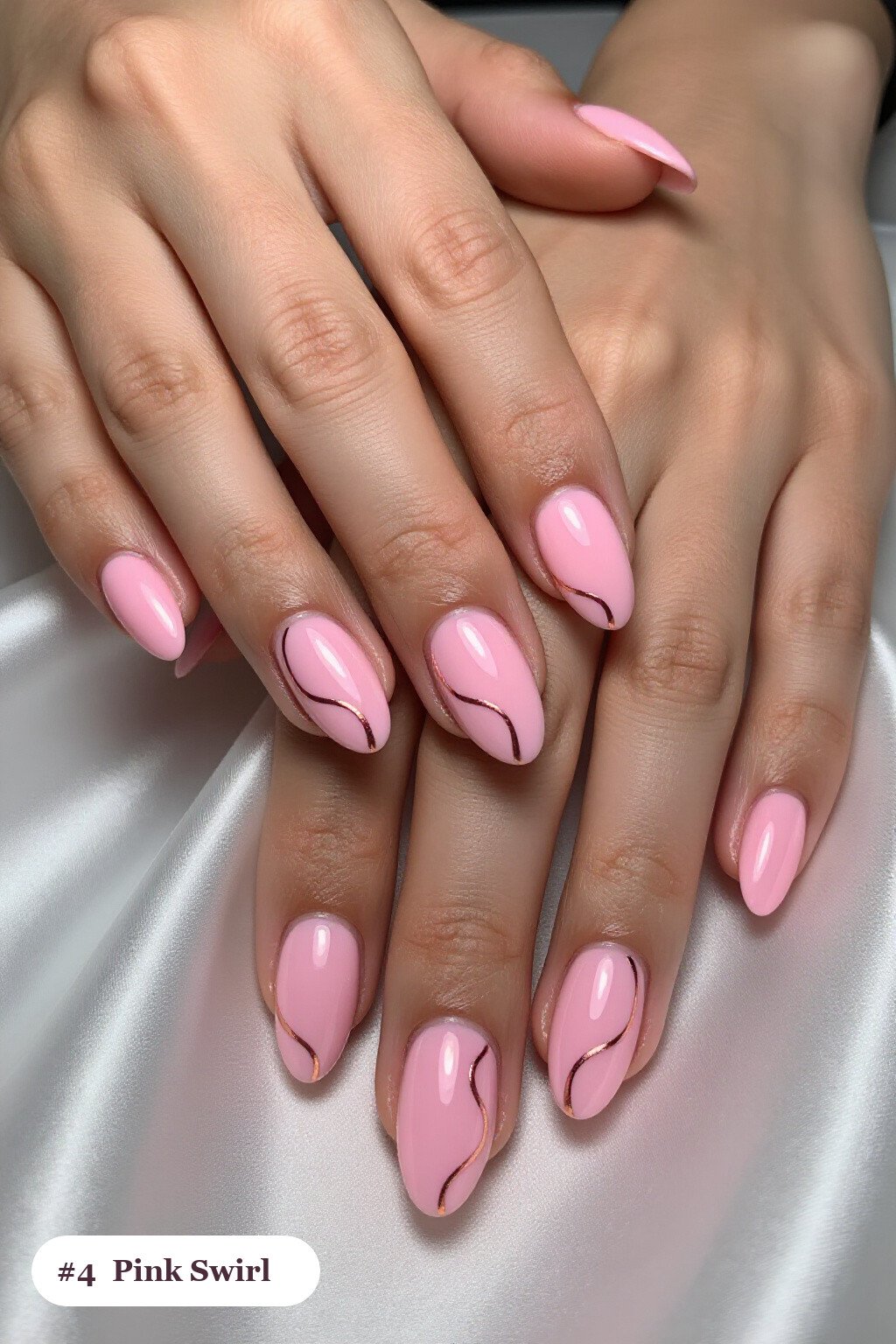 Medium almond pink nails with bold hand-painted swirl lines flowing across every nail in a contrasting colour, with rose gold details - pink nails almond
