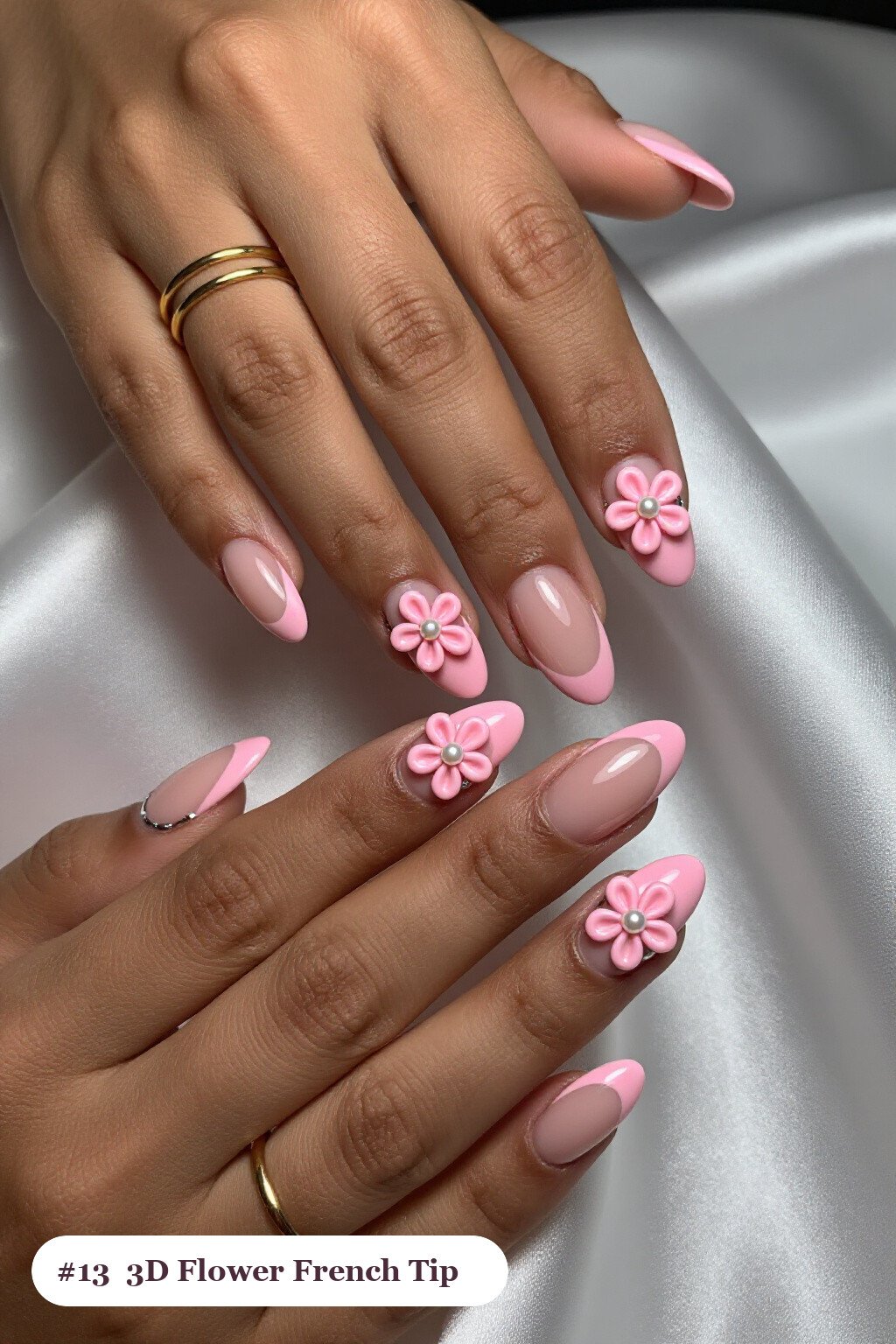 Medium almond pink french tip nails with crisp french tips clearly visible on every nail, styled with raised 3D flowers with pearl centres on two accent nails, with silver chrome details - pink nails almond french tip