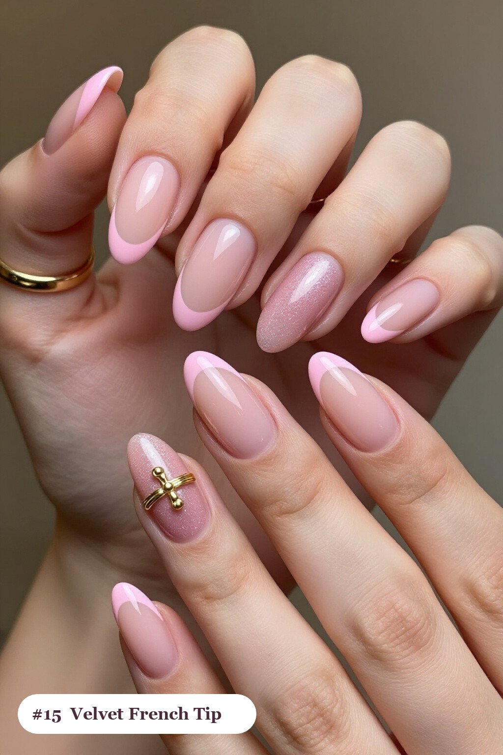 Medium almond pink french tip nails with crisp french tips clearly visible on every nail, styled with a velvet shimmer finish with one glossy accent nail with a gold charm, with gold details - pink nails almond french tip