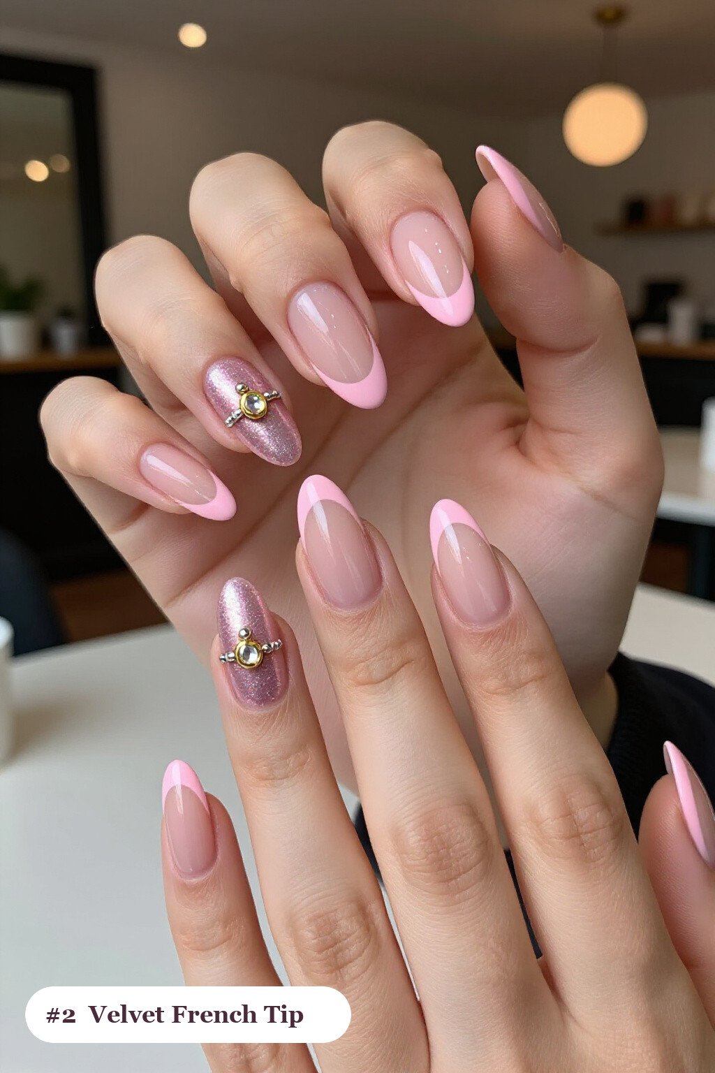 Medium almond pink french tip nails with crisp french tips clearly visible on every nail, styled with a velvet shimmer finish with one glossy accent nail with a gold charm, with silver details - pink nails almond french tip