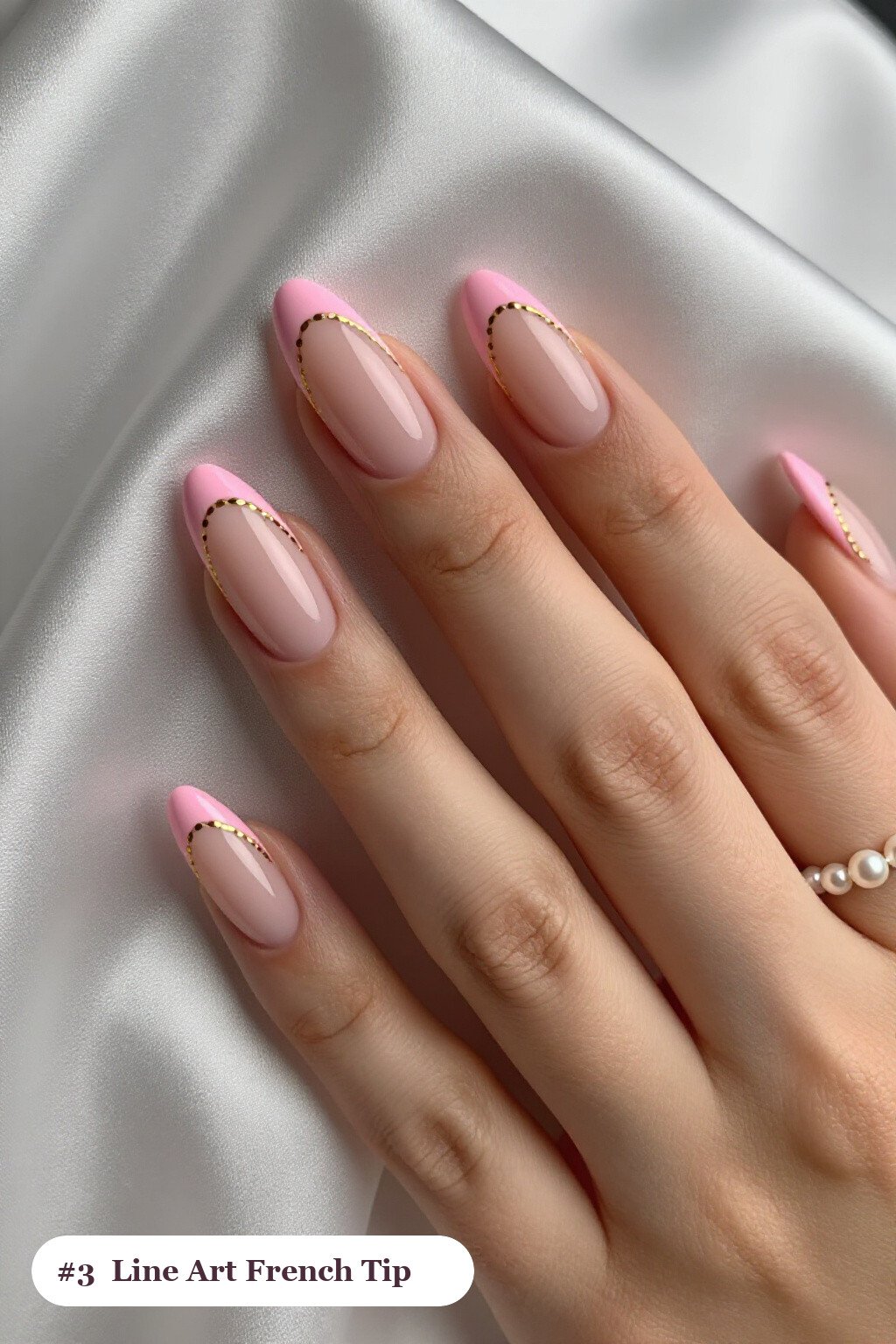 Medium almond pink french tip nails with crisp french tips clearly visible on every nail, styled with fine gold line art and tiny dots drawn across every nail, with soft nude details - pink nails almond french tip