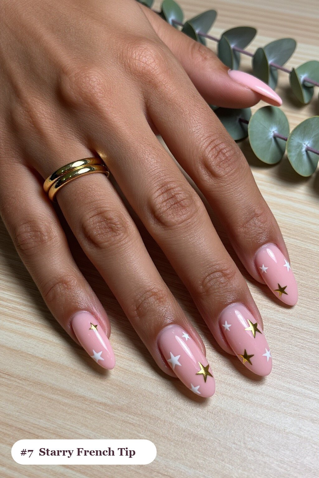 Medium almond pink french tip nails with crisp french tips clearly visible on every nail, styled with white and gold stars and sparkles painted on every nail, with gold details - pink nails almond french tip