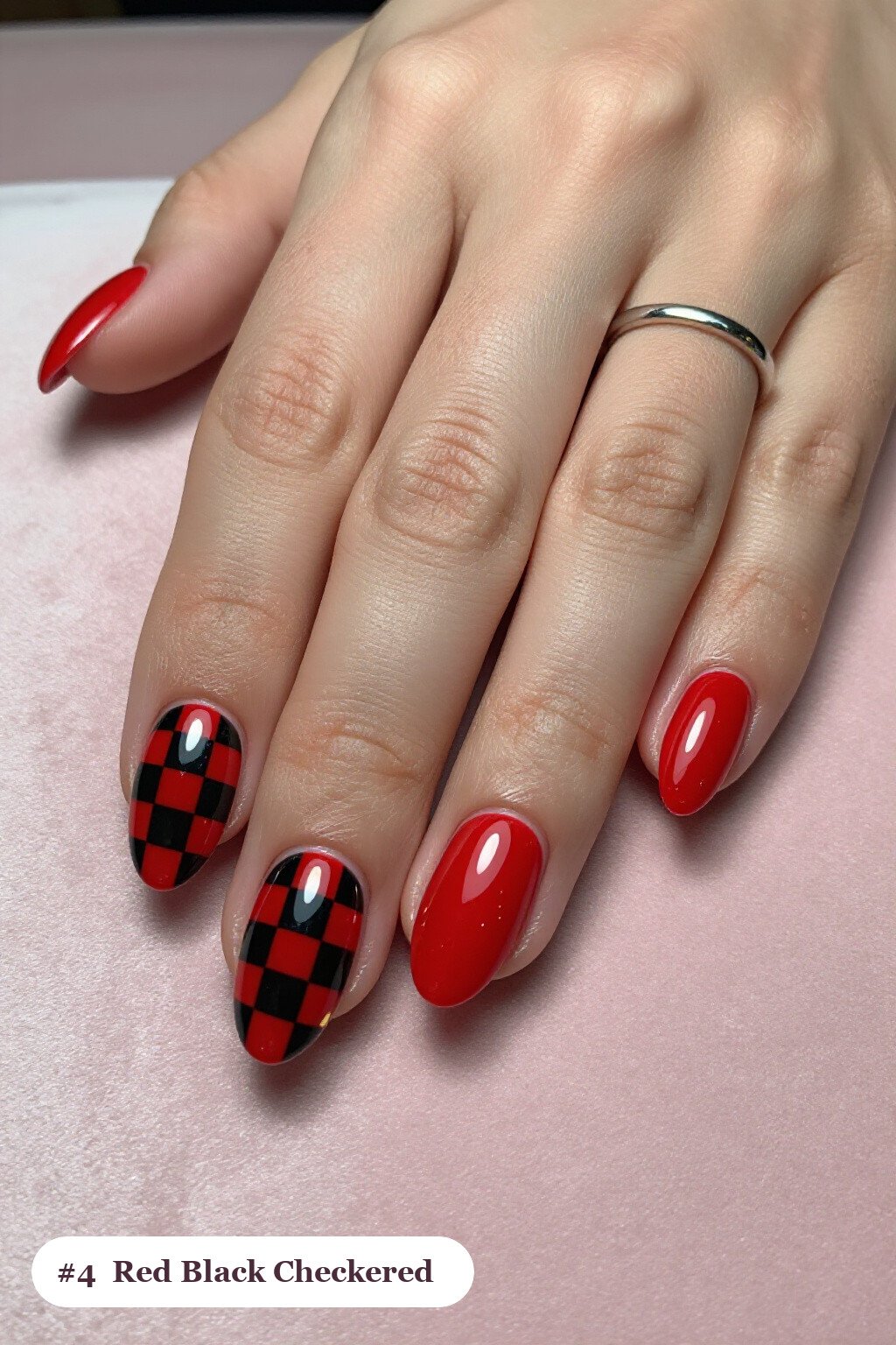 Medium oval red black nails with a bold checkerboard pattern on two accent nails and solid colour on the rest, with gold details - red and black nails