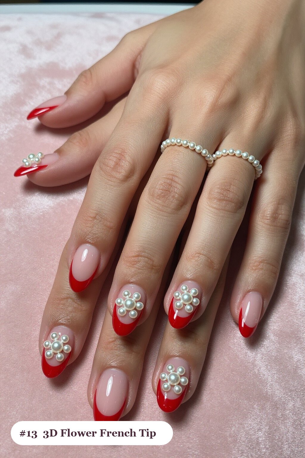 Medium oval red french nails with crisp french tips clearly visible on every nail, styled with raised 3D flowers with pearl centres on two accent nails, with pearl details - red french nails Medium oval red french nails with crisp french tips clearly visible on every nail, styled with raised 3D flowers with pearl centres on two accent nails, with pearl details - red french nails