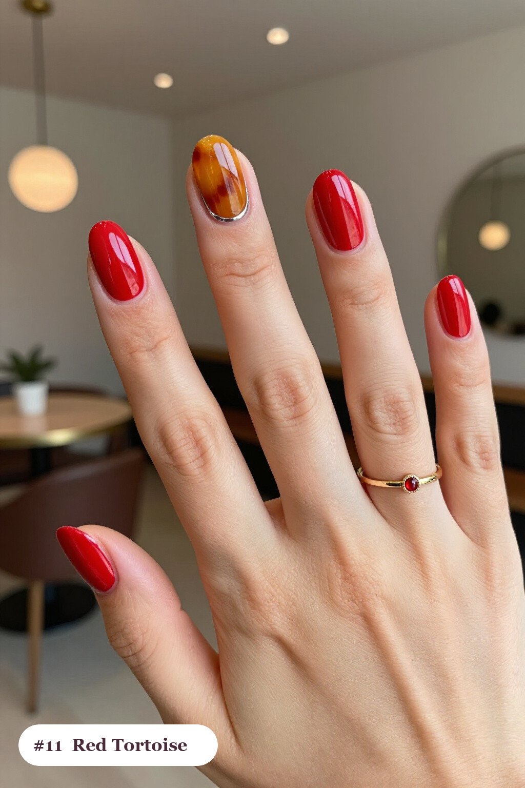 Medium oval red nails with glossy amber tortoiseshell on two accent nails, with silver chrome details - red nails