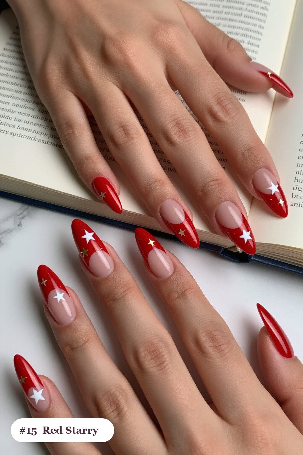 Long stiletto red nails with white and gold stars and sparkles painted on every nail, with soft nude details - red nails